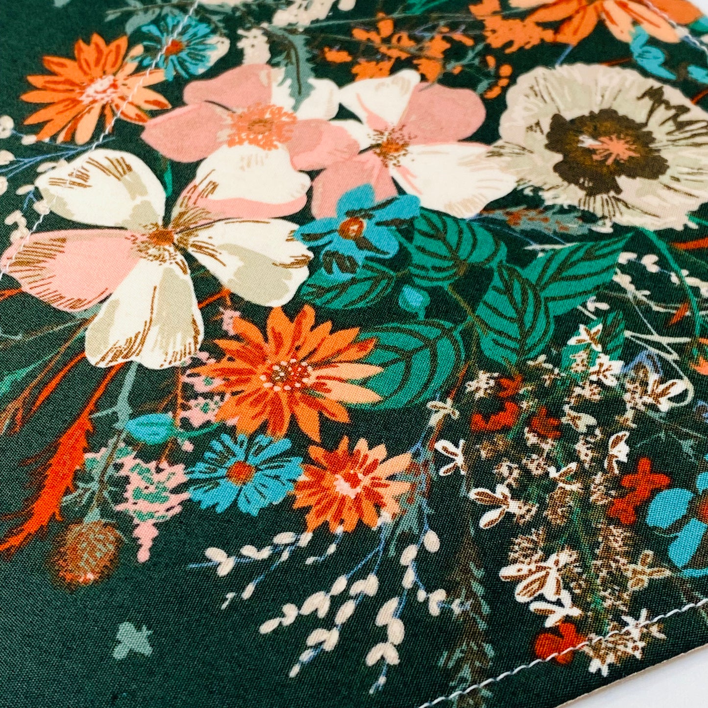 Dog bandana with a wildflower bouquet on an emerald green background.