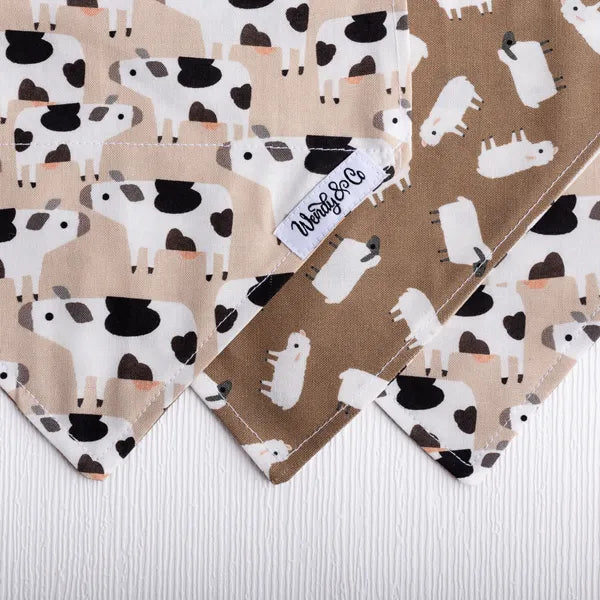 Close up of reversible dog bandana in cow and sheep print.