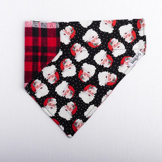 Festive Holiday dog bandana with Santa heads and cozy red plaid reverse.
