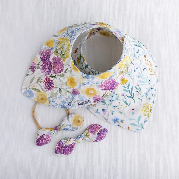 Baby bib with yellow floral fabric from the Buttercup collection with bows.