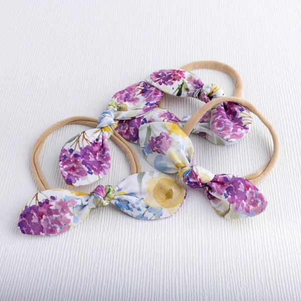Handmade baby bows in purple and yellow floral.