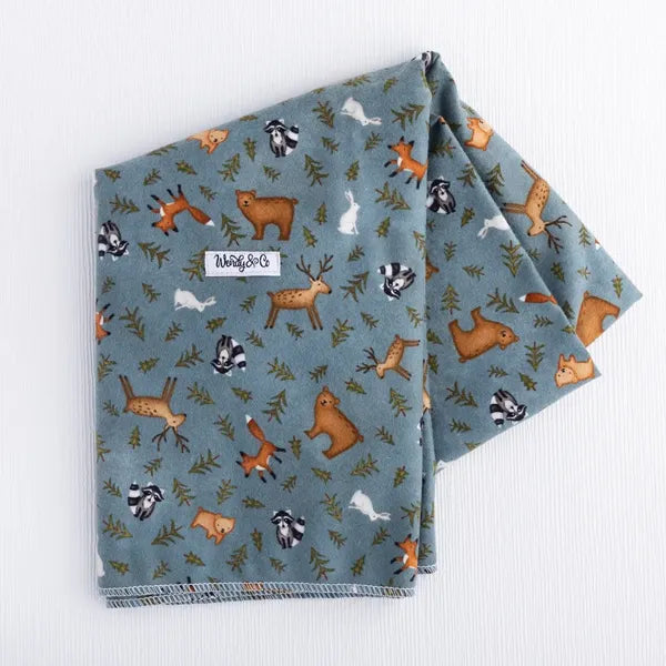 Whispering Woods blanket featuring soft woodland and tree pattern.