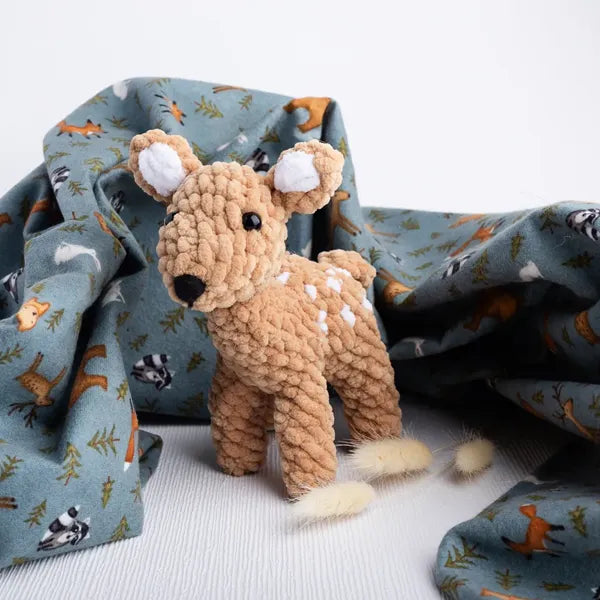 Fauna the deer, a handmade crochet toy in soft earth tones, pairs with Whispering Woods baby items.
