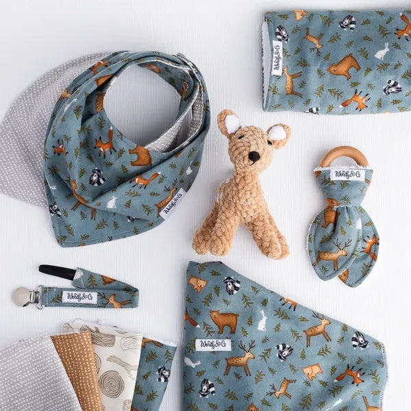 Whispering Woods baby collection with bib, blanket, burp cloth, teether, washcloth, and hairbow in forest print.