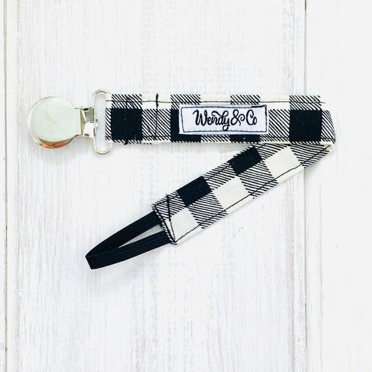 Black and cream check pacifier clip.