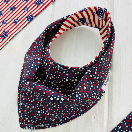 Navy handmade bandana baby bib with red and cream stars, reverse side red and cream stripes with navy stars.
