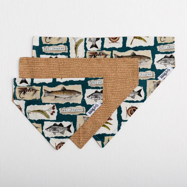 Two dog bandanas with a fly-fishing, trout pattern in teal, cream, and brown, with a solid tan reverse side, displayed on a white textured background.
