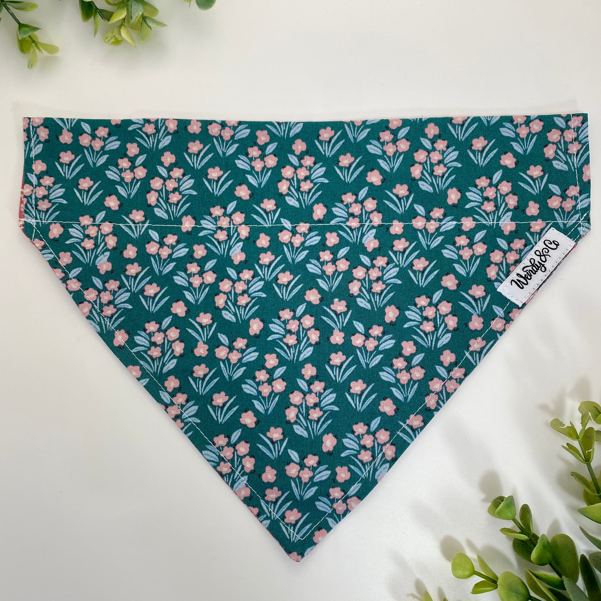 Reversible dog bandana that slides over the collar in teal and pink floral.