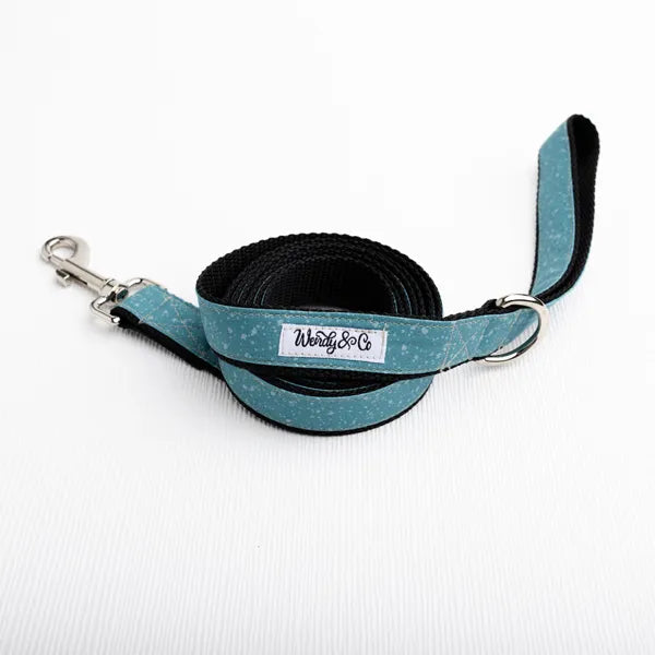 A teal and black dog leash with a silver metal clasp and a white brand label reading 'Wendy & Co' on a white textured background.