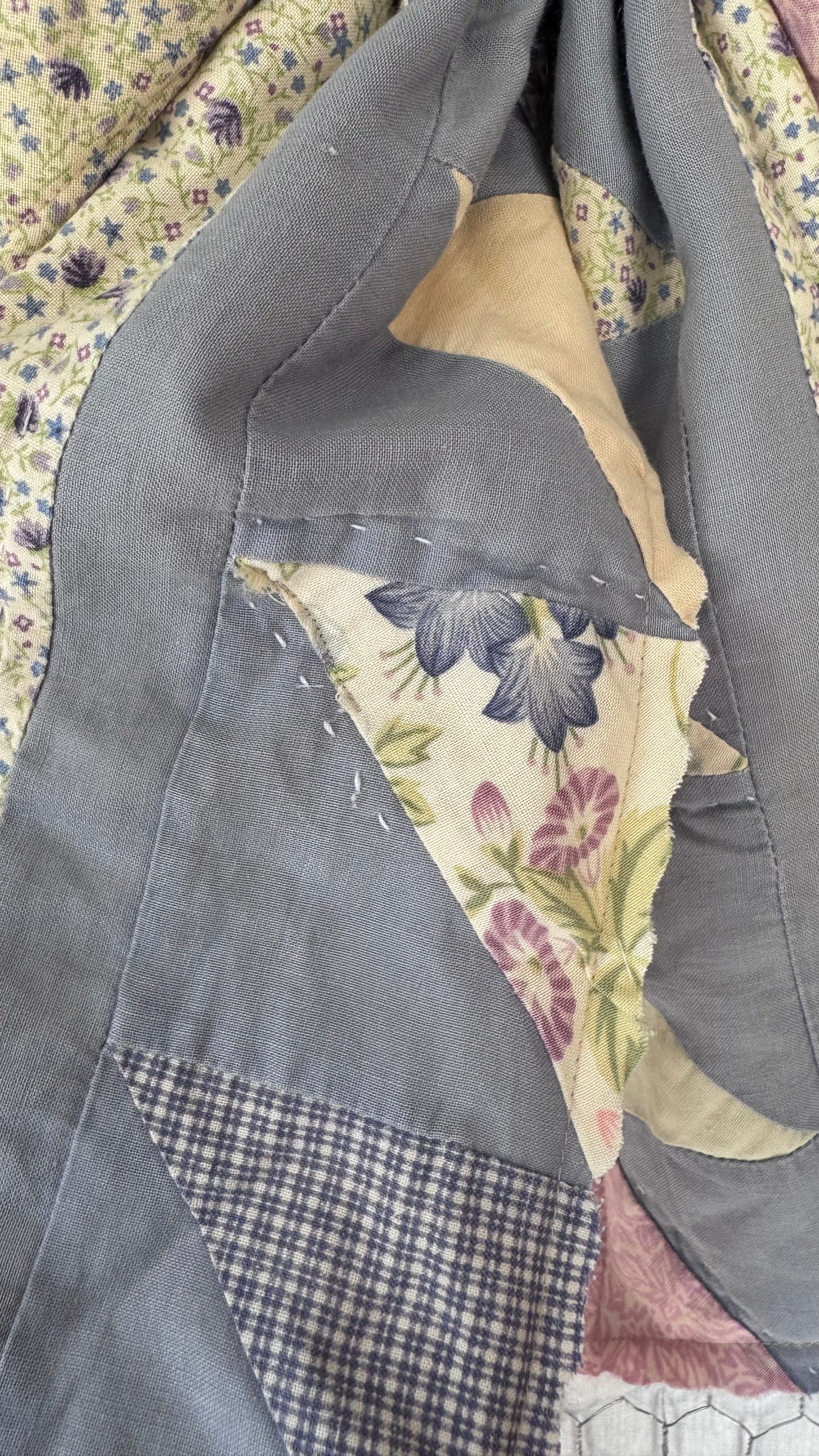 Patchwork quilt with floral and plaid patterns on a floral background
