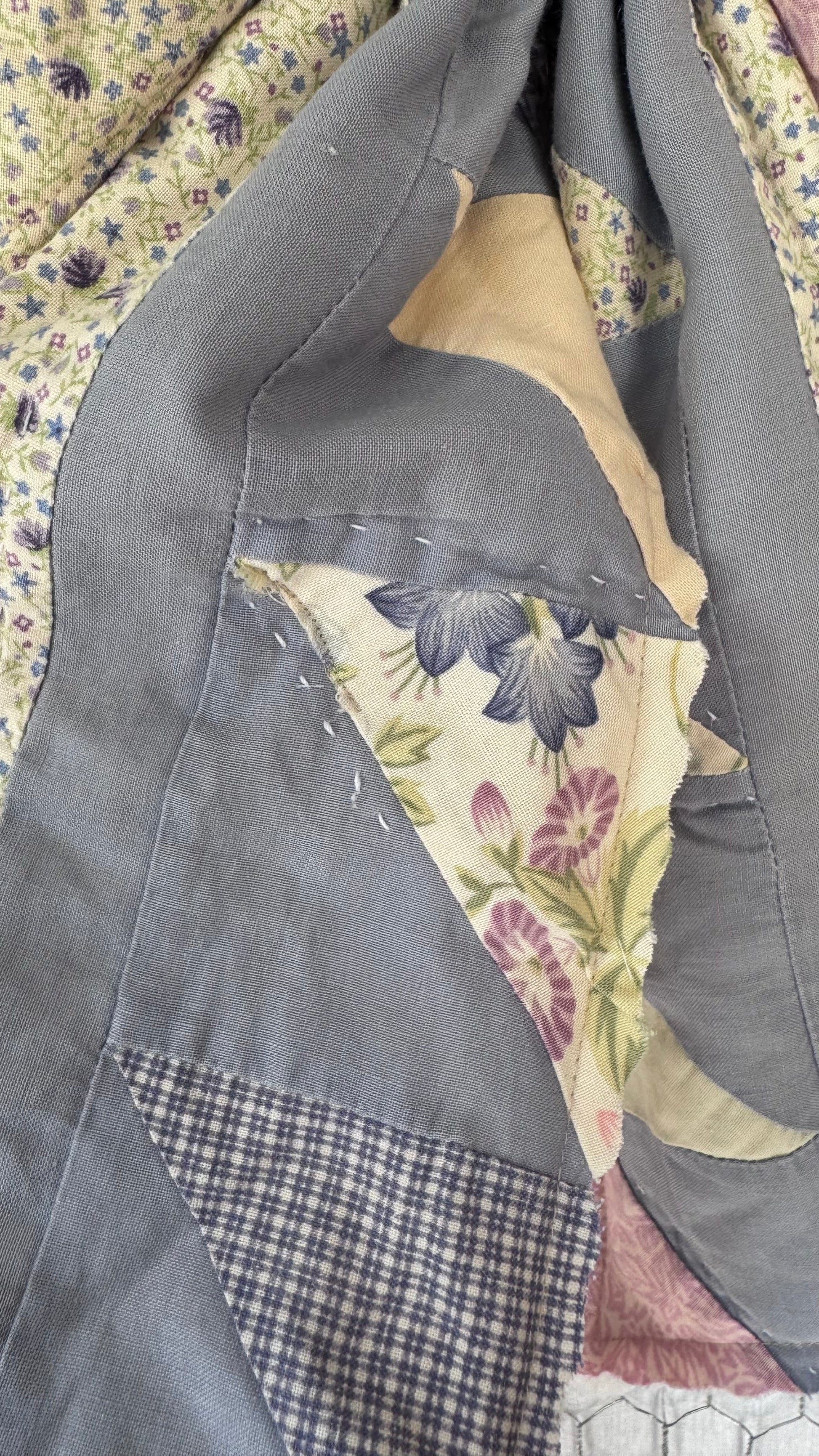 Patchwork quilt with floral and plaid patterns on a floral background