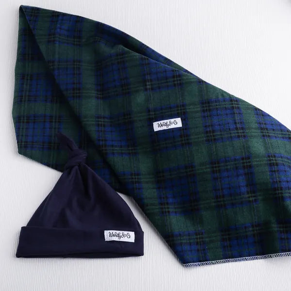 Green and navy plaid blanket and beanie.