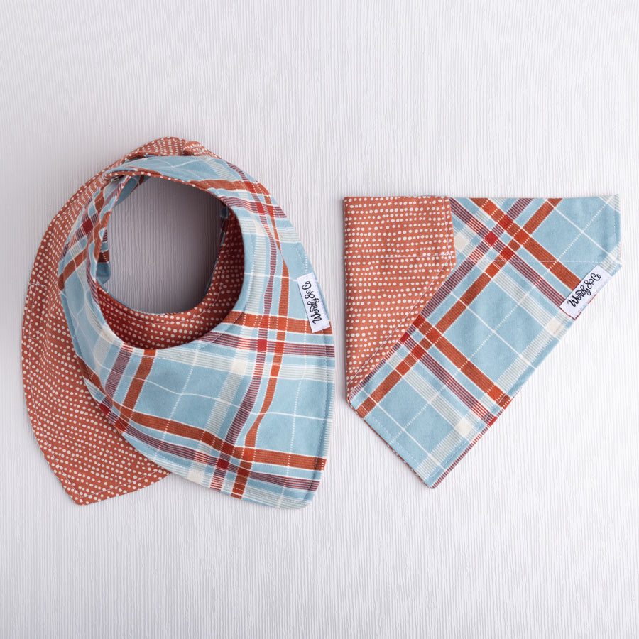 Matching baby bib and dog bandana in slate blue plaid.