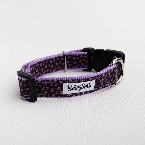 A purple and black patterned dog collar with a black plastic buckle.