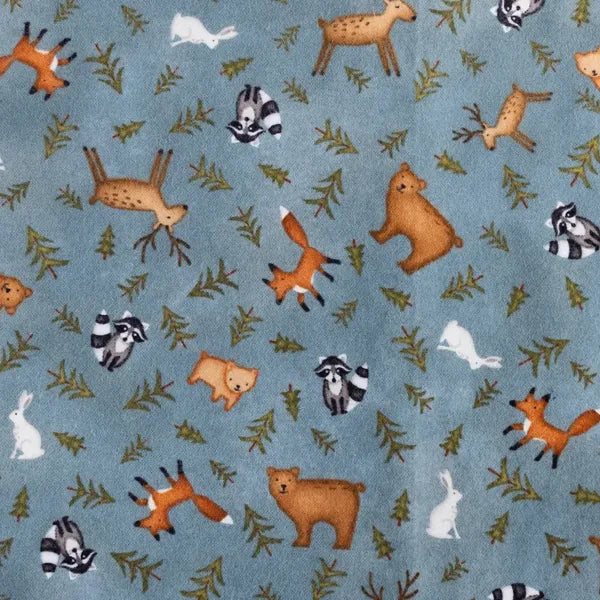 Close up of Whispering Woods fabric with forest animals on soft blue.