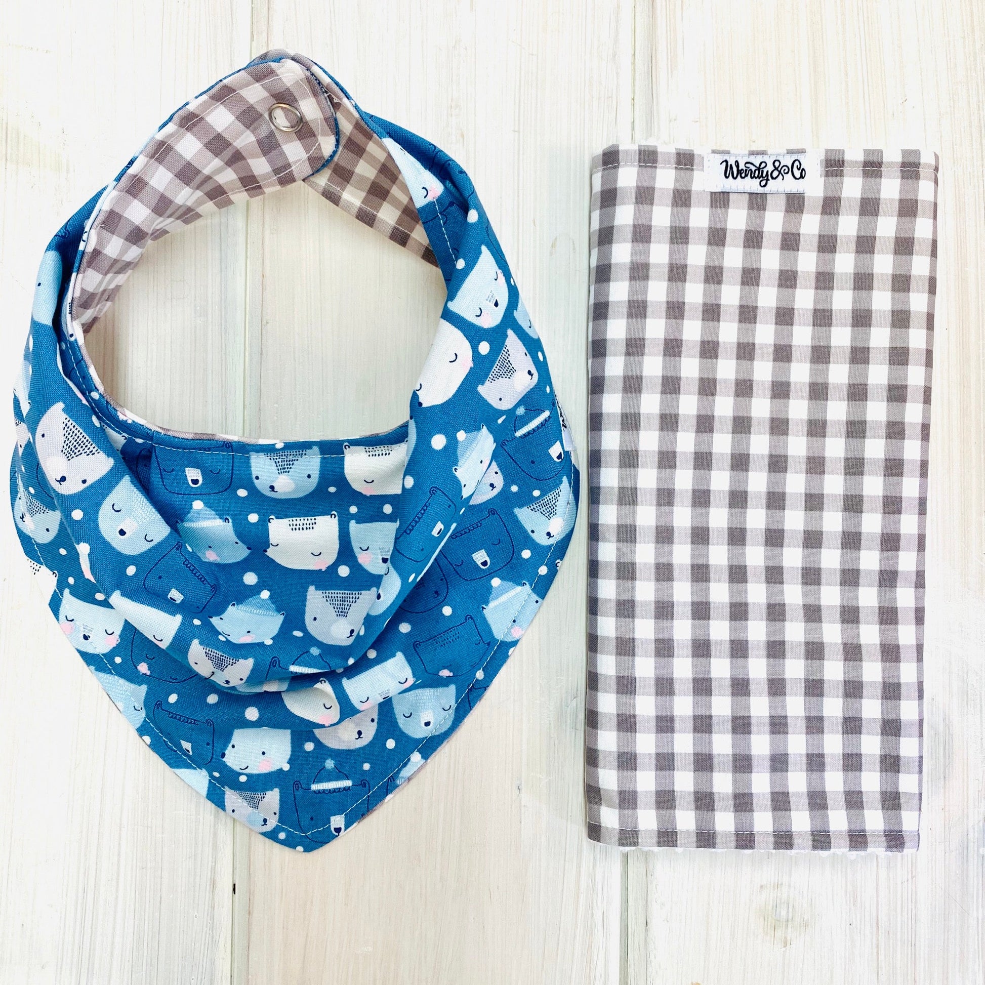 Handmade bandana bib, reversible, shown with burp cloth. Blue fabric with cute bear heads scattered in rows.