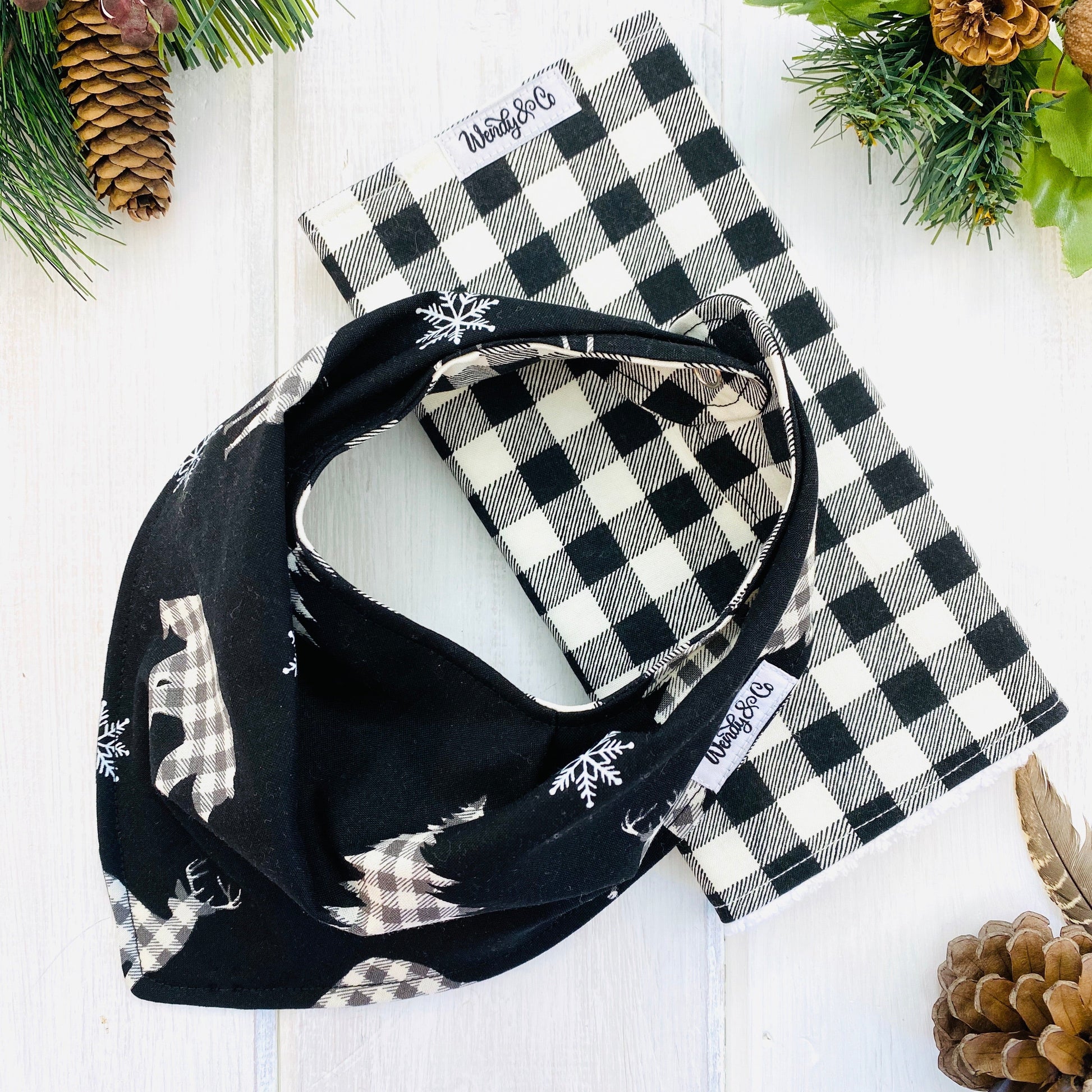 Bandana bib with burp cloth, black and cream check bears on black background.