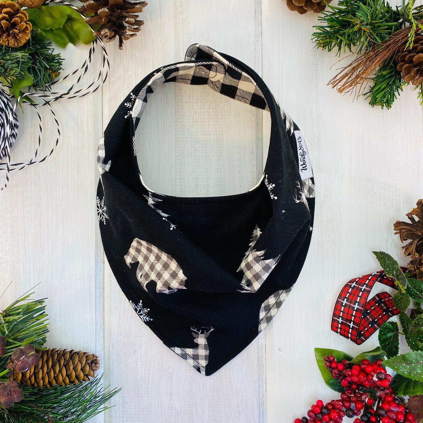 Reversible bandana bib in Black & cream check bears on black background,