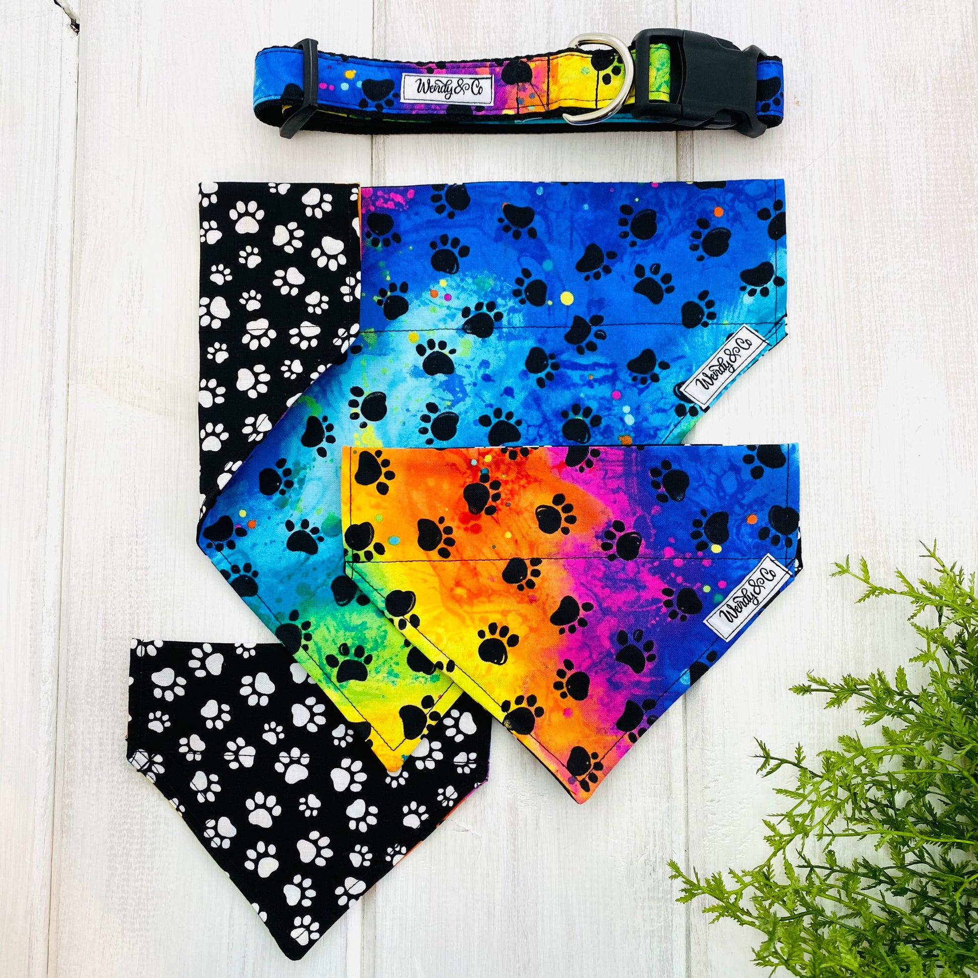 Bright tie dye fabric with black paws handmade into dog collar and bandanas.