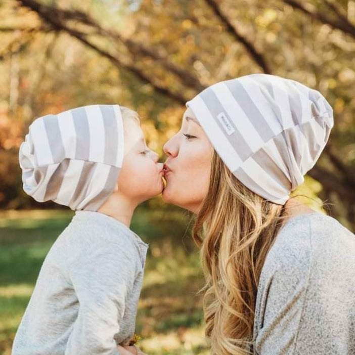 Mother and toddler in matching beanies.