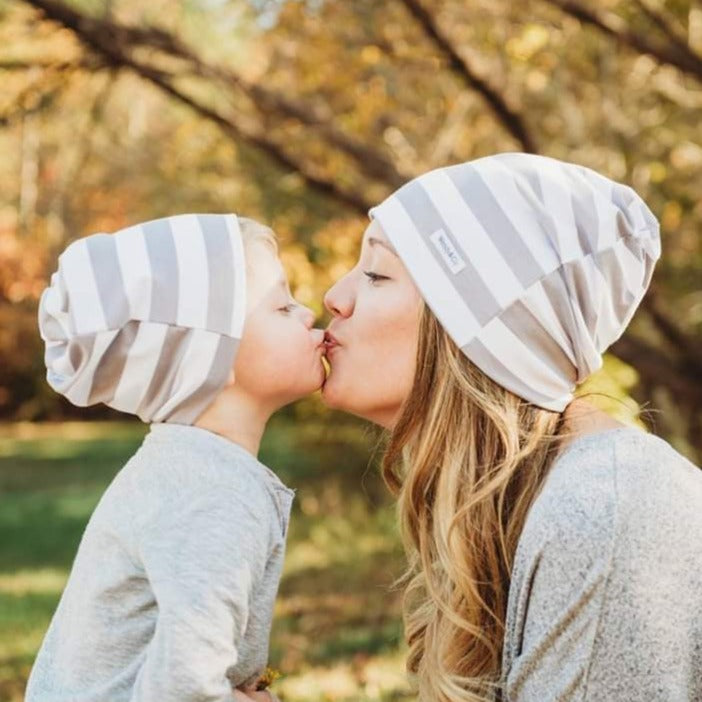 Mother and son with matching beanies in a fall scene.