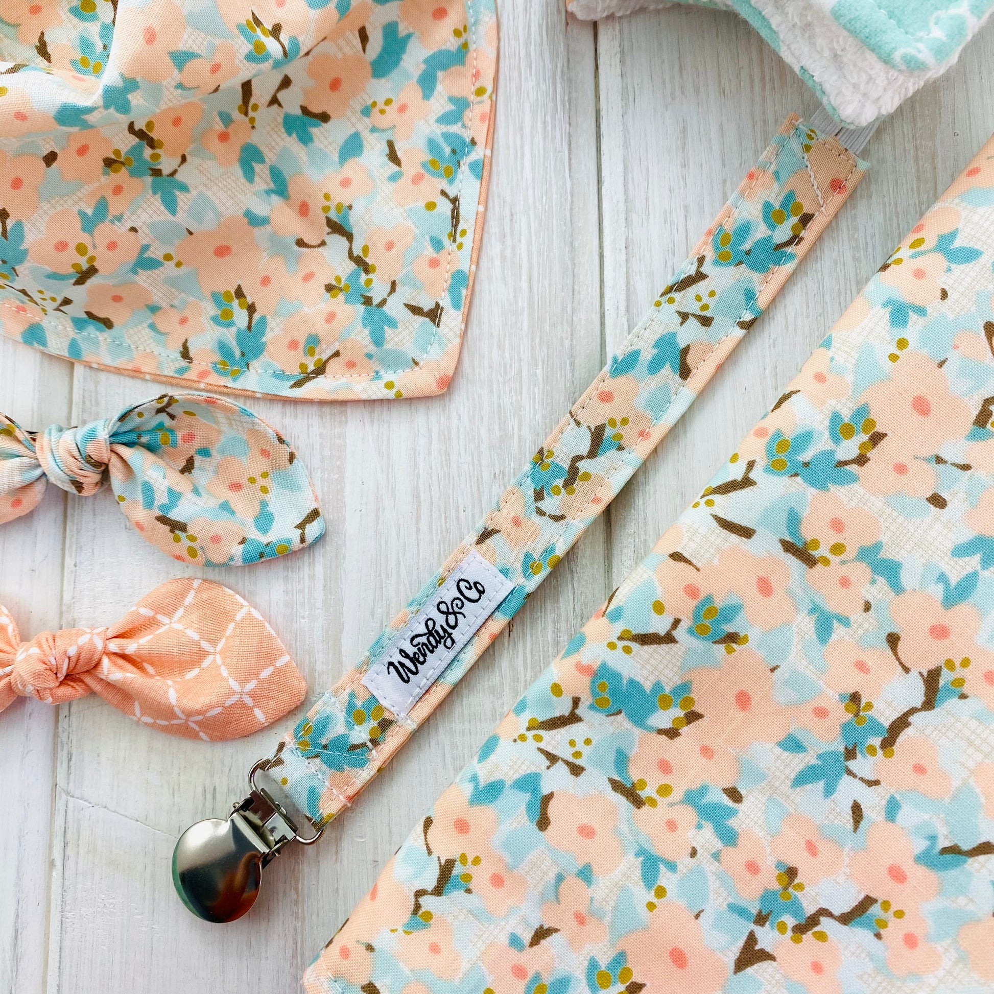 Pacifier clip in peach and blue dogwood floral.