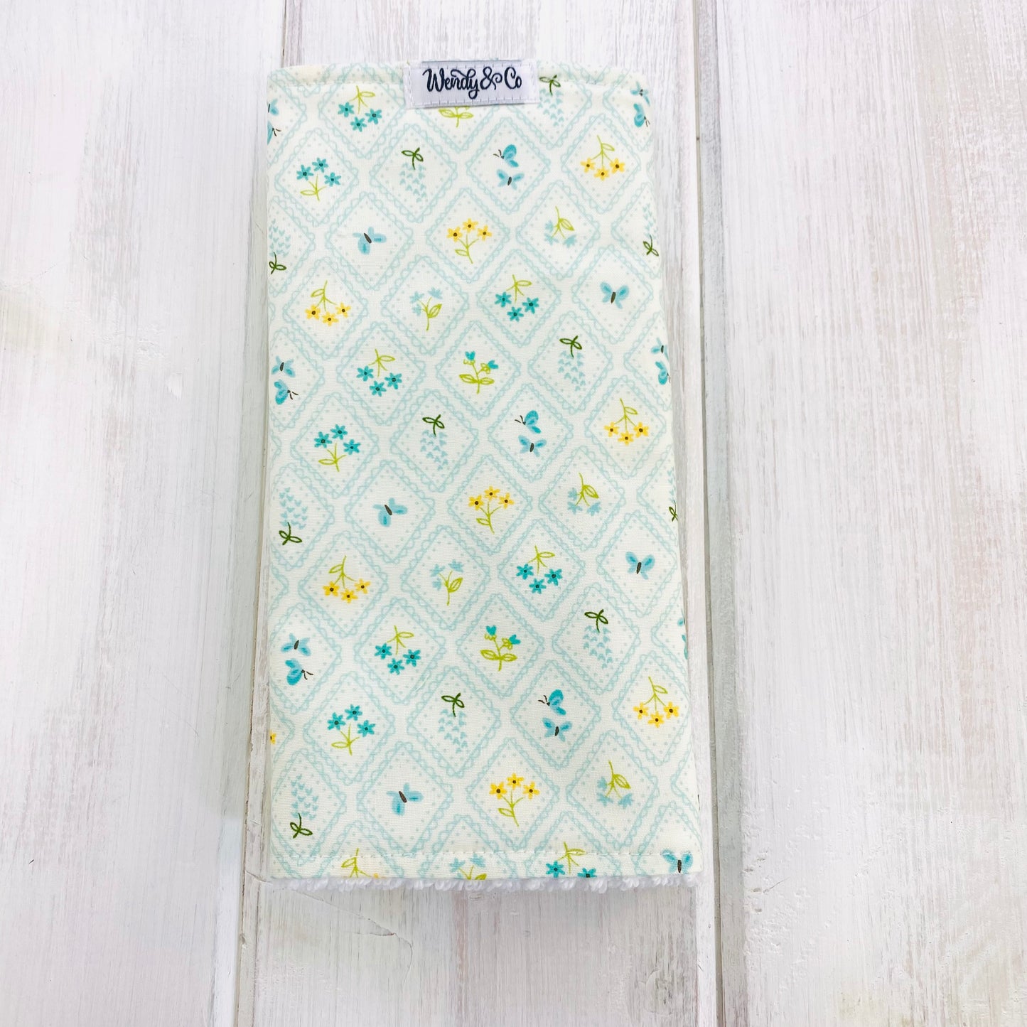 Baby burp cloth in light blue floral with Black-eyed Susan, blue Lupins, and butterflies.