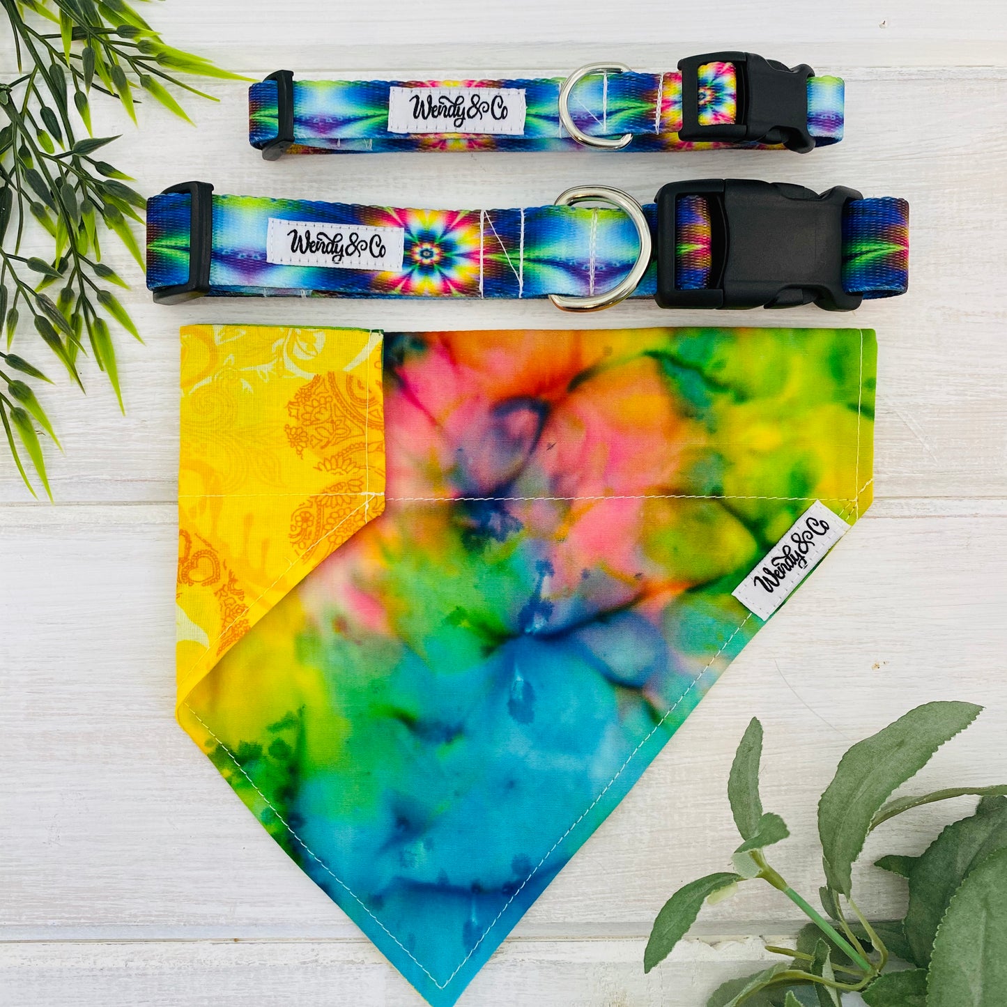 Vivid tie-die collar and bandana with groovy rainbow colors in concentrations of blue, yellow, green and pink.