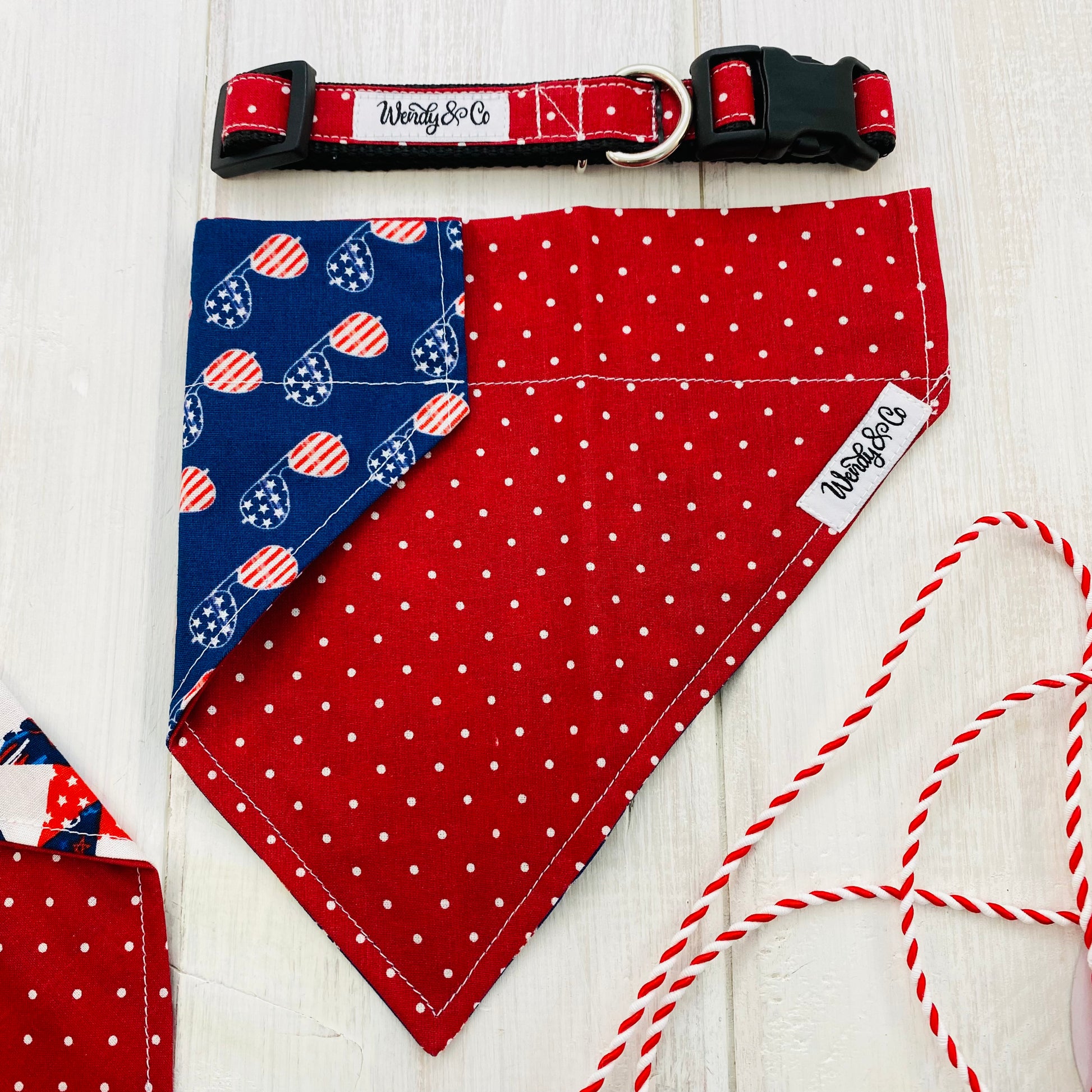 Festive reversible dog bandana in red dot and reverses to navy USA sun glasses. Shown with red dot collar.
