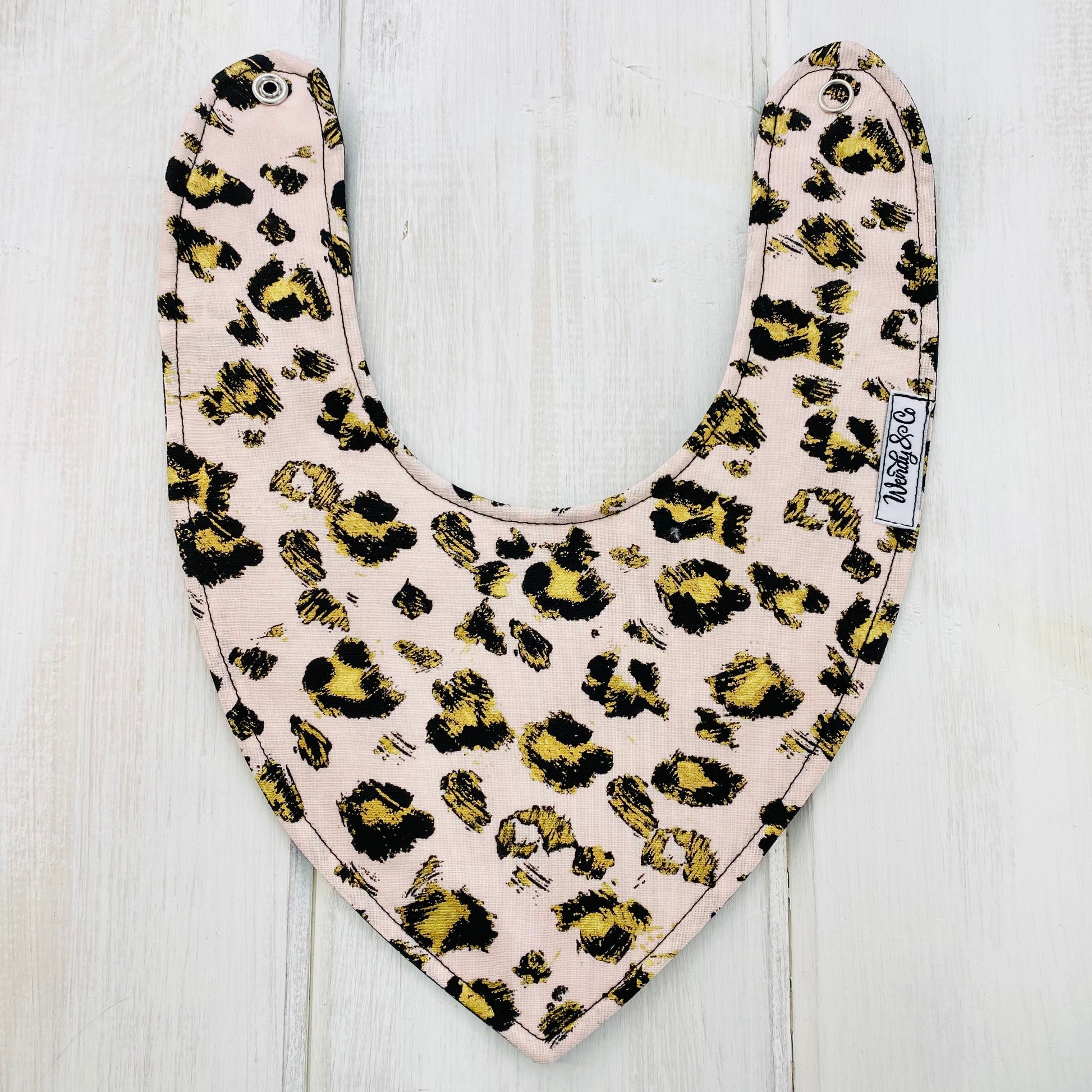 Blush cheetah print bandana bib with gold accents, animal print, reversible and waterproof bib.