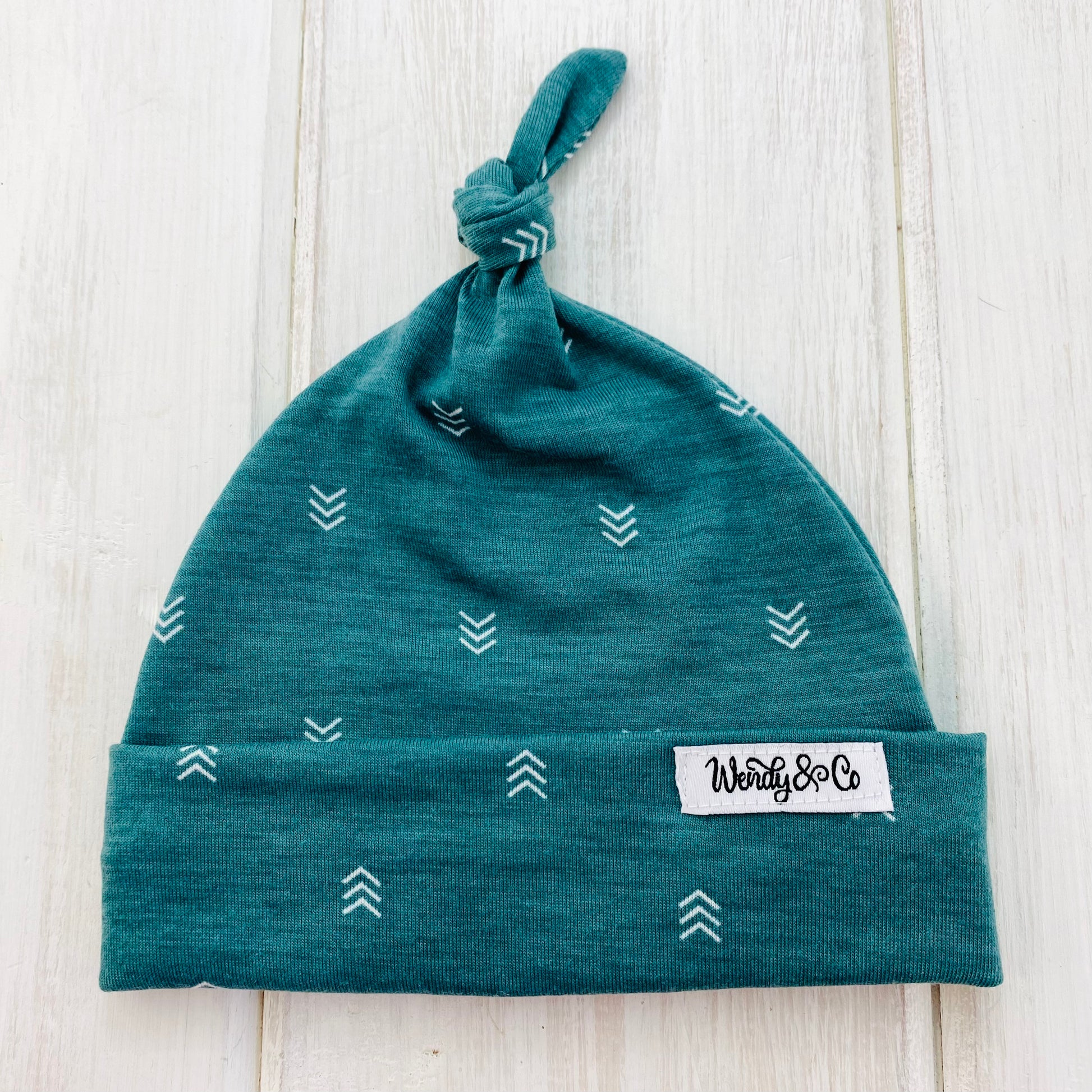 Soft newborn hat in green with arrows.