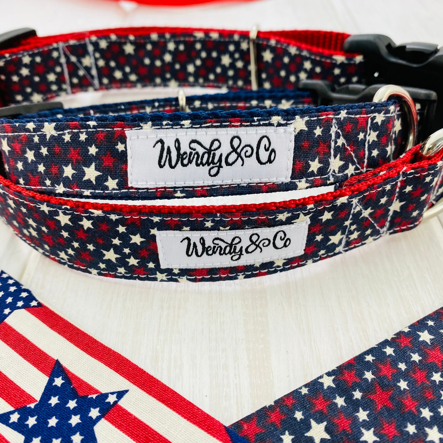Dog collar, navy fabric with red and white stars on red webbing, close up.