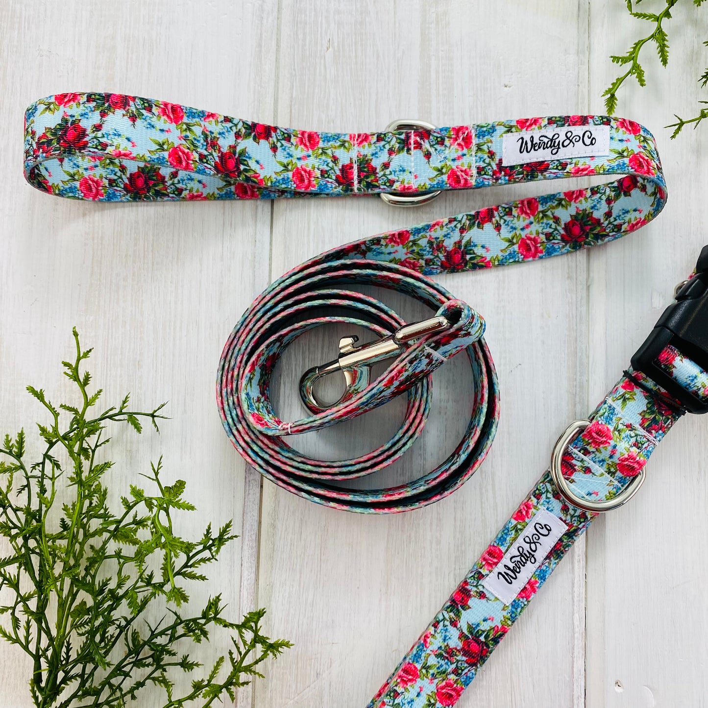Girly floral dog leash with red roses on blue background.