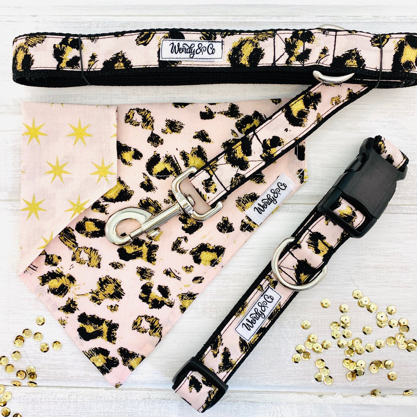 Blush pink cheetah animal print fabric with black and gold accents. Collar, leash and reversible dog bandana.