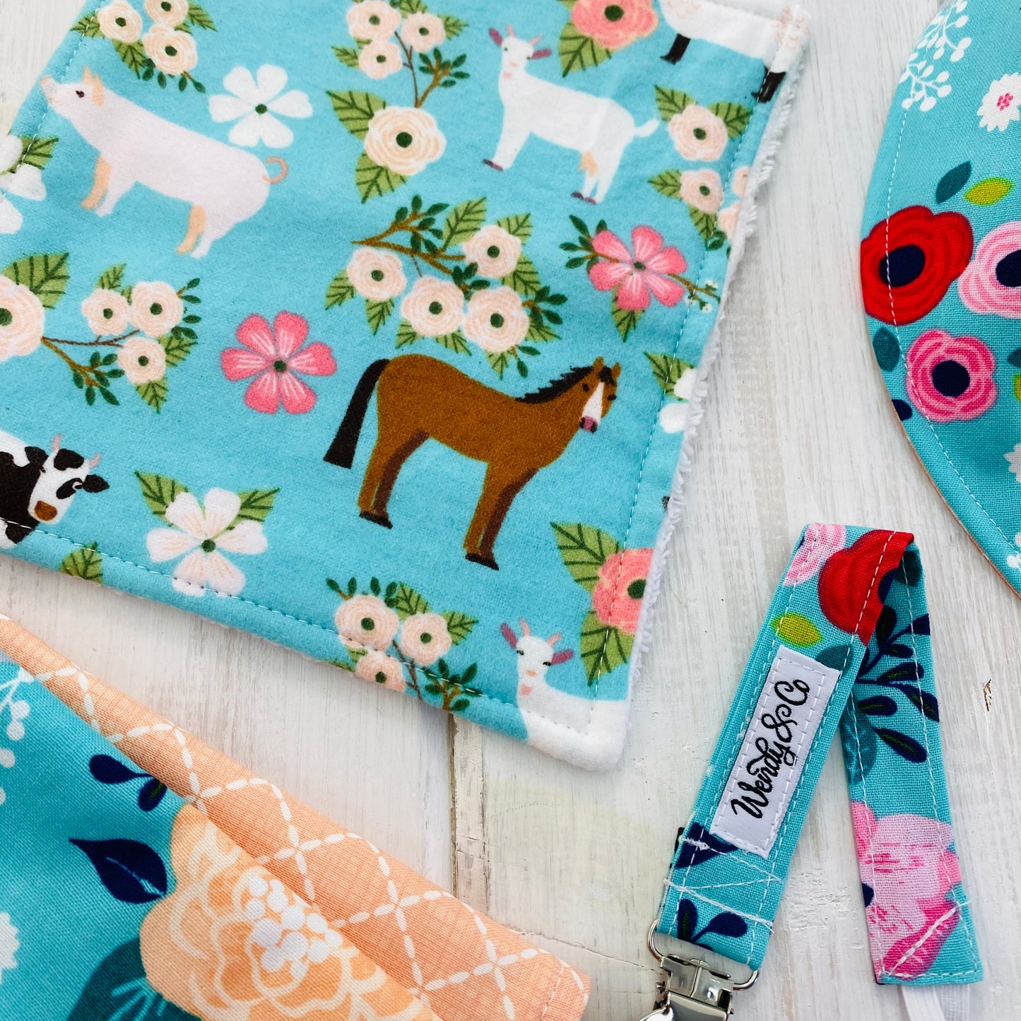 Cow, horse, pig on bright floral fabric.