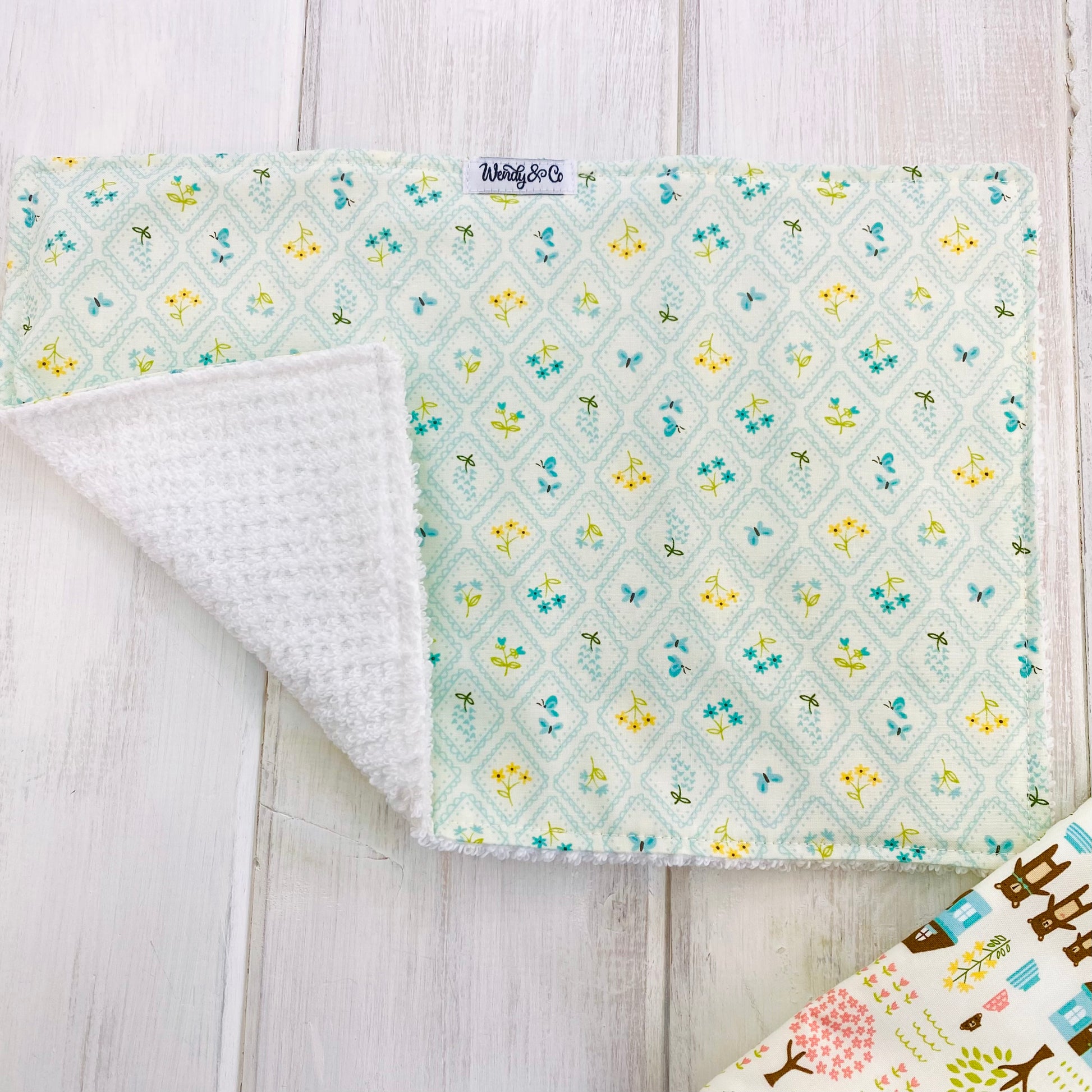 Baby burp cloth in light blue floral with Black-eyed Susan, blue Lupins, and butterflies