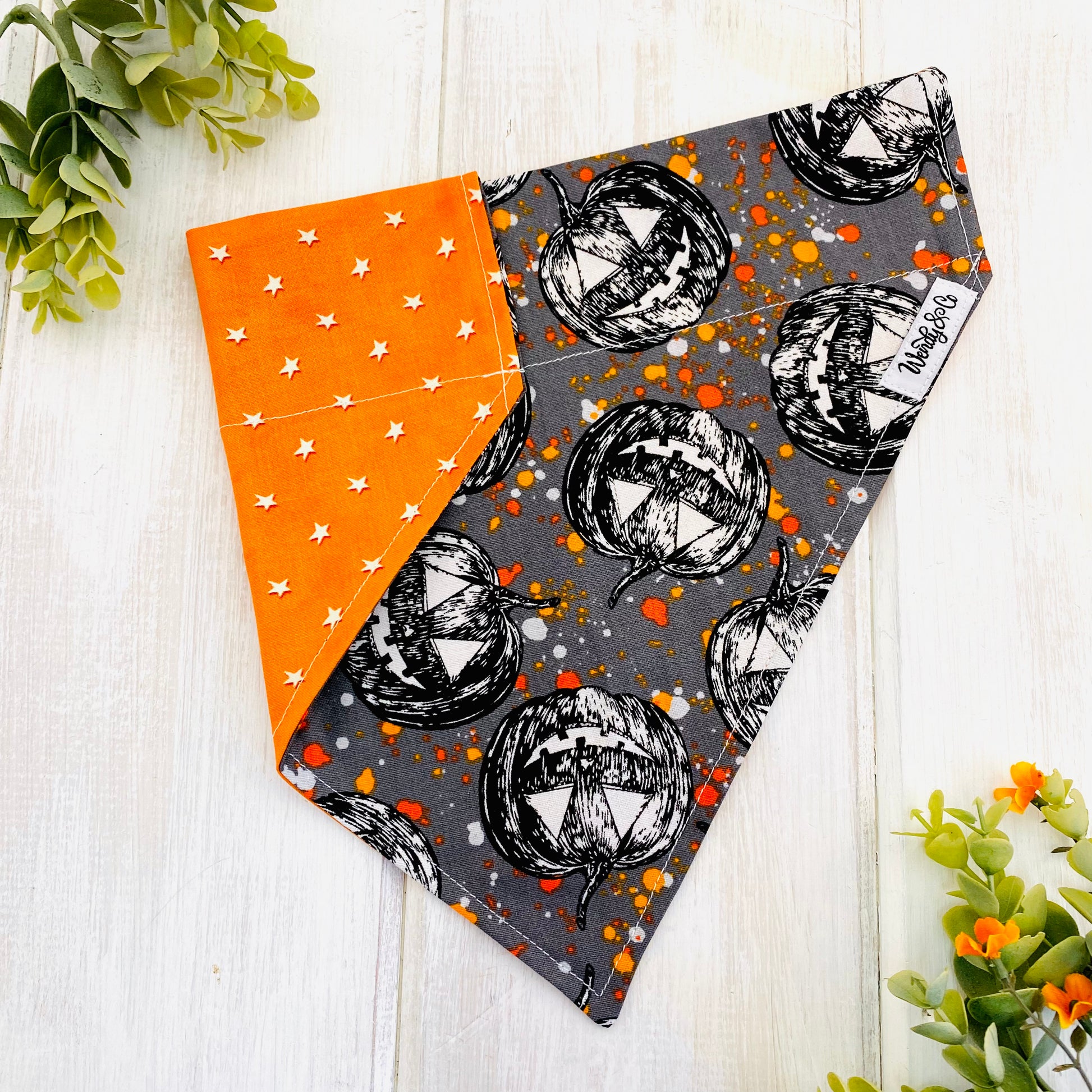 Halloween dog bandana with glow-in-the-dark stars on one side and spooky pumpkins on the reverse.