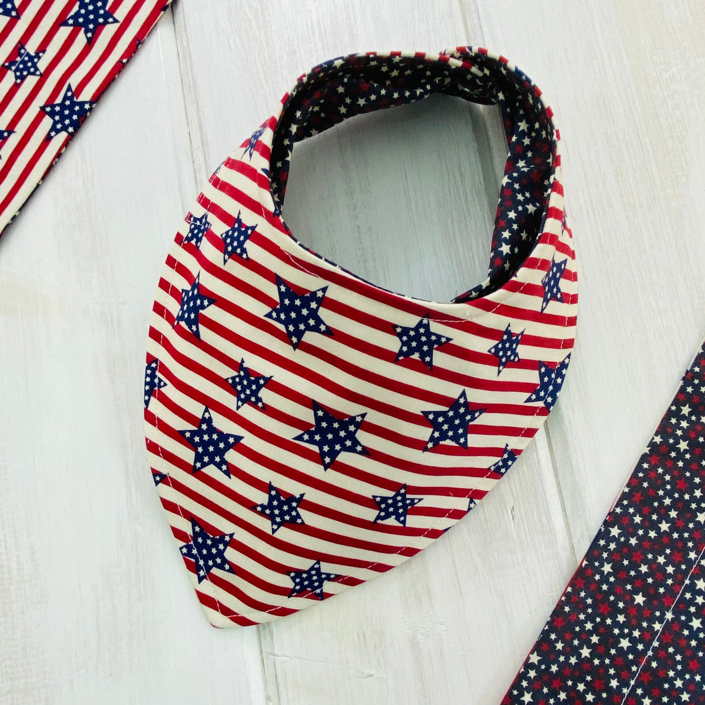 Reverse side of bandana bib in red and cream stripes with navy stars.