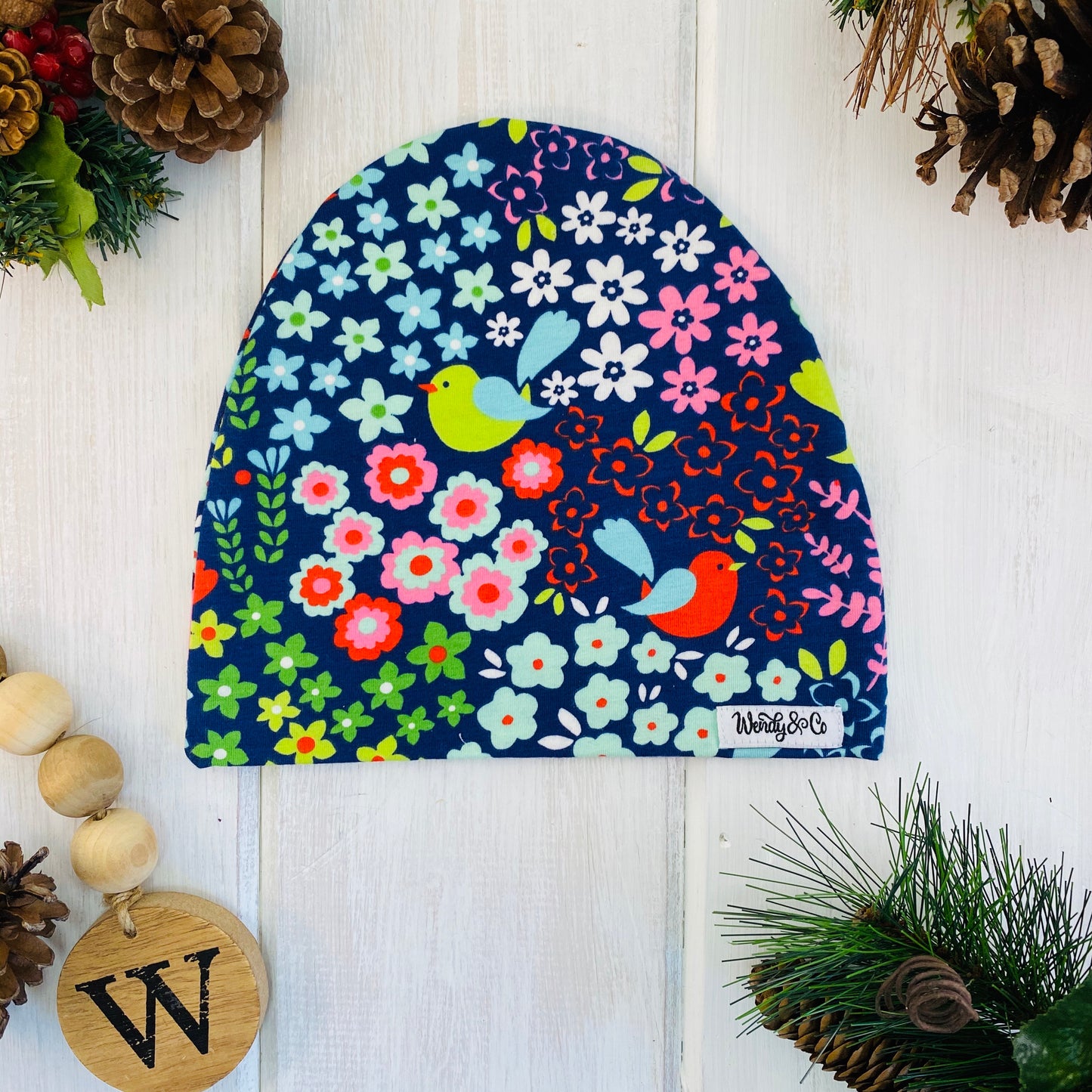 Bright floral pattern with red, mint, pink, blue, green flowers and birds on a navy background. Slouchy beanie modern fit for girls.