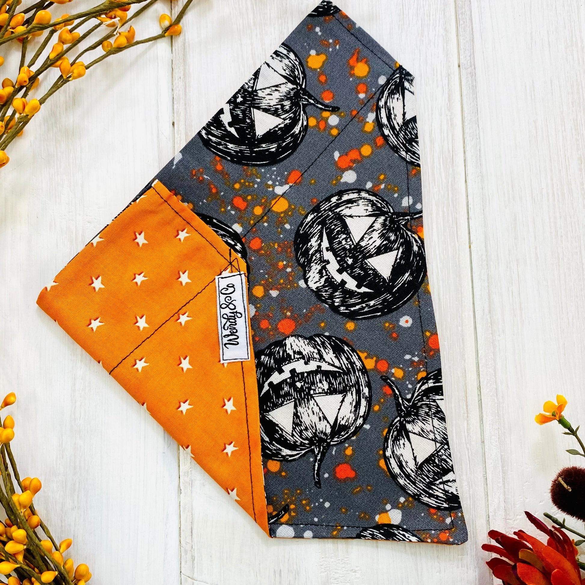 Reversible Halloween dog bandana, glows in the dark, spooky pumpkins and orange star pattern.