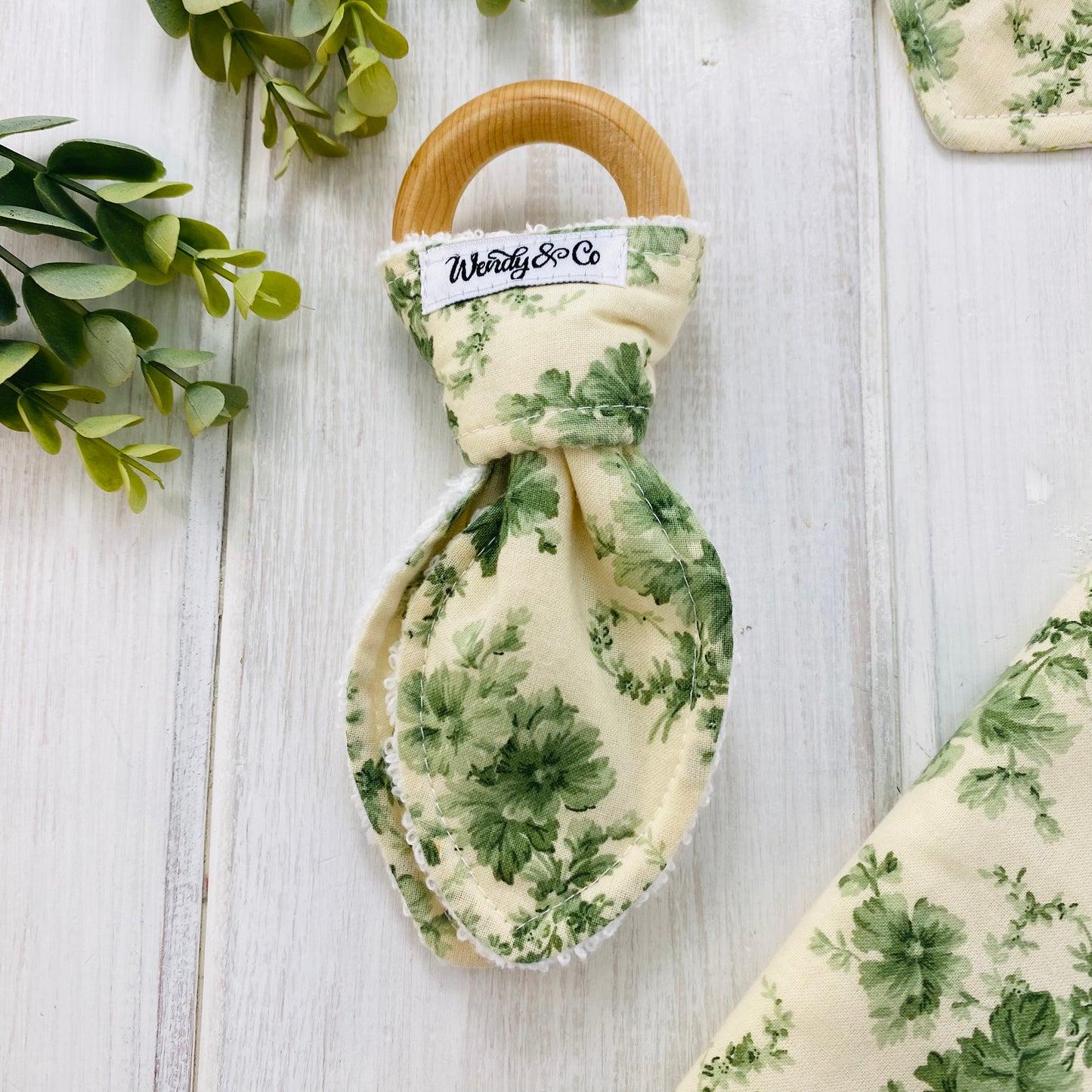 Sage green floral organic teether for baby.