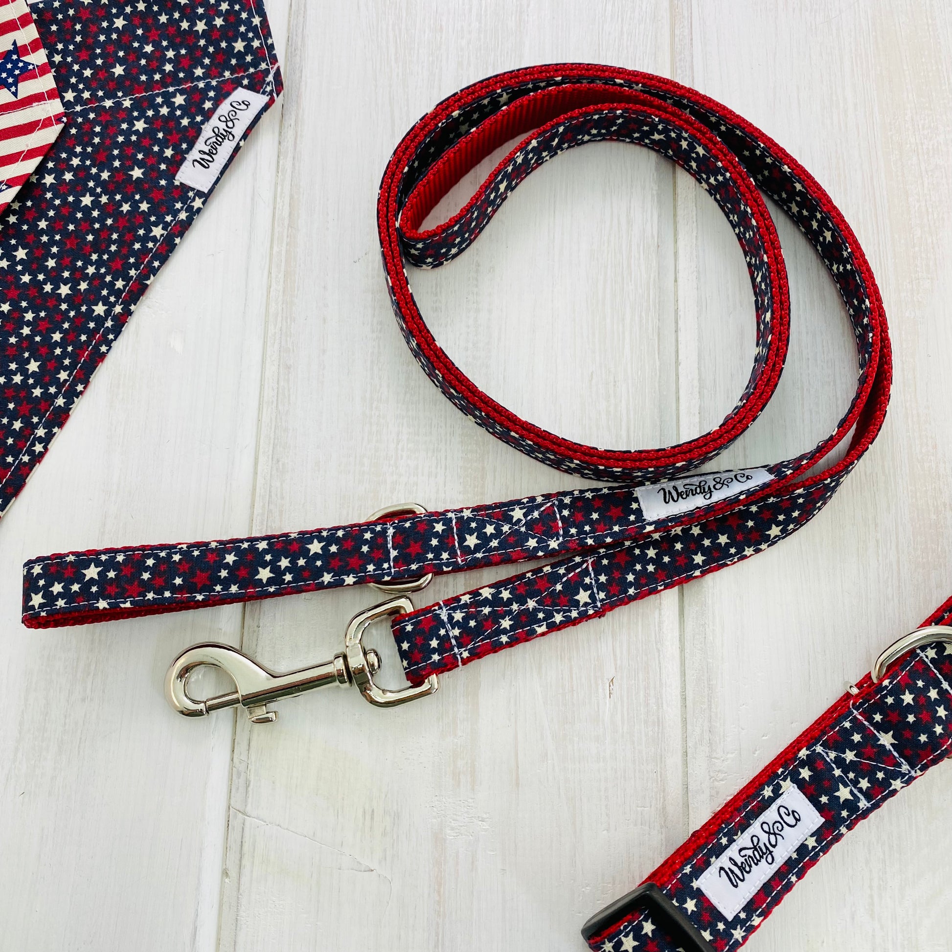 Dog leash in navy background with white and red stars sewn onto red webbing. Shown with matching bandana.