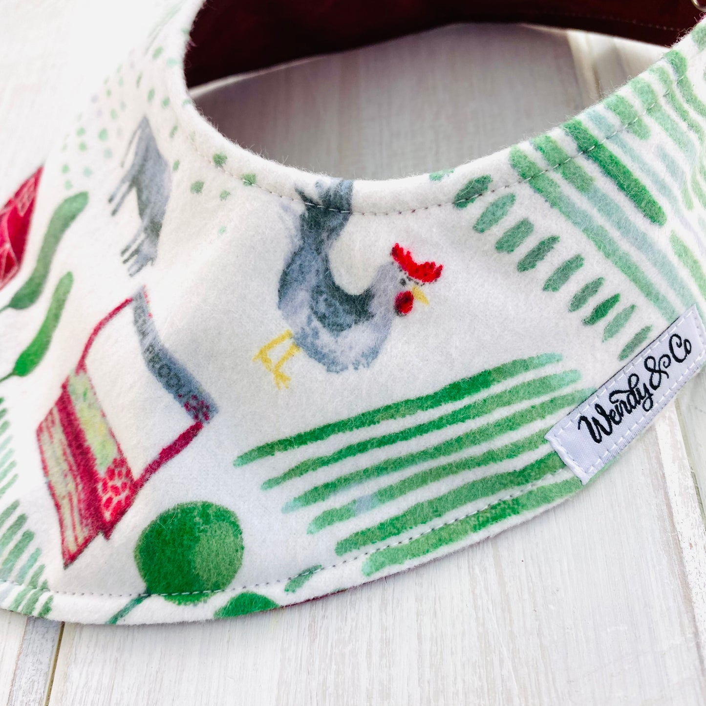 Chicken, cow and farm scene in watercolor fabric baby bib.