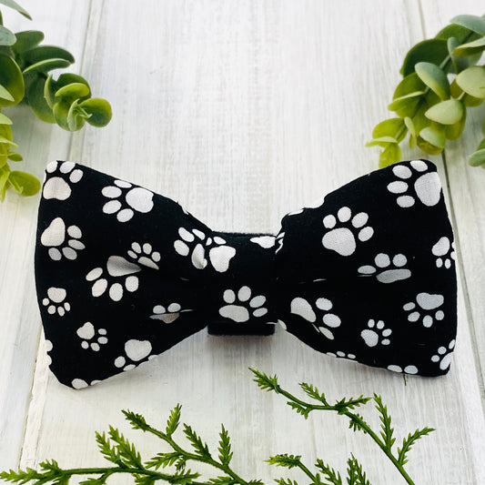 Dog bow tie, black with white paws.