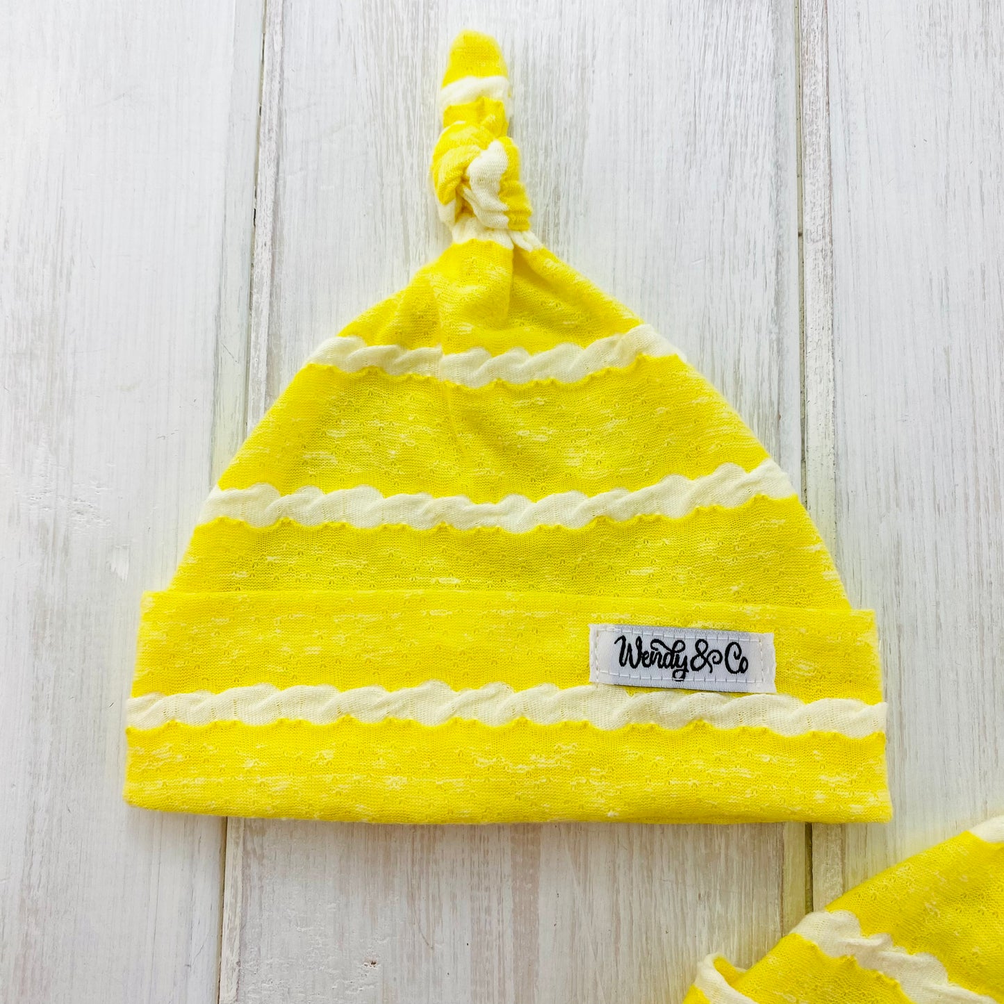Canary yellow newborn hat with textured stripe.