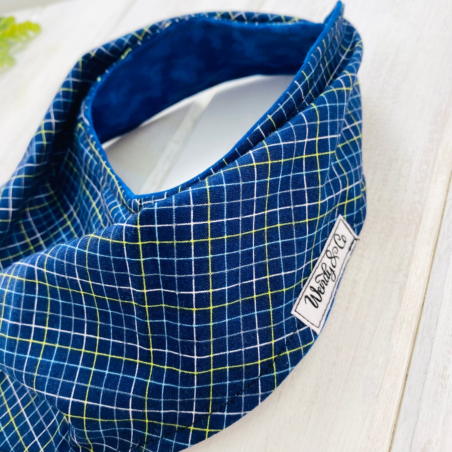 Close up of navy plaid baby bib.